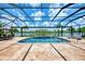Screened-in pool area with beautiful water view, featuring fountains, tile flooring, and ample lounge space at 20686 Valprato Ct, Venice, FL 34293