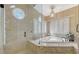 Luxurious bathroom showcasing a corner jacuzzi tub and a glass-enclosed shower with a rain shower head at 4221 Escondito Cir, Sarasota, FL 34238