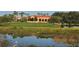 Clubhouse overlooking a lake on the golf course, surrounded by lush greenery and palm trees at 4221 Escondito Cir, Sarasota, FL 34238