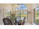Dining area with a glass table and chairs, a chandelier, and sliding glass doors to a screened patio at 4221 Escondito Cir, Sarasota, FL 34238