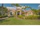 Charming single-story home with an arched entryway, clay tile roof, and verdant lawn at 4221 Escondito Cir, Sarasota, FL 34238