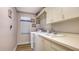 Laundry room with white appliances, white cabinets, laminate counter, and a utility sink at 4221 Escondito Cir, Sarasota, FL 34238