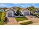 Attractive home featuring a three-car garage, well-manicured lawn, and complemented by a charming brick driveway at 5607 Tidewater Preserve Blvd, Bradenton, FL 34208