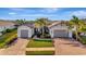Stunning exterior of a modern home with a three-car garage, complemented by lush landscaping and a brick driveway at 5607 Tidewater Preserve Blvd, Bradenton, FL 34208