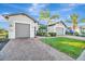 Attractive exterior view showcasing a well-maintained home with a brick driveway, lush lawn, and a convenient three-car garage at 5607 Tidewater Preserve Blvd, Bradenton, FL 34208