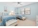 Bright bedroom features two twin beds with blue bedding, a ceiling fan, and ample natural light at 5724 Doral Dr, Sarasota, FL 34243