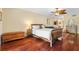 Warm bedroom with hardwood floors, wooden furniture, and a ceiling fan at 5724 Doral Dr, Sarasota, FL 34243