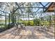 Enclosed patio featuring brick flooring, with views of the lake and landscaping at 5724 Doral Dr, Sarasota, FL 34243