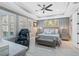 Comfortable main bedroom with a tray ceiling, shutters, and bench at the foot of the bed at 6625 Dovekey Dr, Sarasota, FL 34241