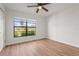 Bright bedroom with wood-look flooring, ceiling fan, and a large window offering plenty of natural light at 7507 3Rd Nw Ave, Bradenton, FL 34209