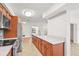 Open concept kitchen features stainless steel appliances, wood cabinets, light countertops, and views to dining room at 7507 3Rd Nw Ave, Bradenton, FL 34209