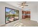 Light-filled living room has a ceiling fan, tile floors, and large sliding glass doors offering pool views at 7507 3Rd Nw Ave, Bradenton, FL 34209