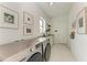 Well-lit laundry room with modern washer, dryer, and granite countertop at 9048 Bernini Pl, Sarasota, FL 34240