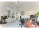 Bright office space with wood desk, black chair and stylish decor with view into hallway at 9048 Bernini Pl, Sarasota, FL 34240