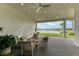 Covered patio with comfortable seating overlooking a serene lake view at 9048 Bernini Pl, Sarasota, FL 34240