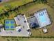 Aerial view of the community pool, tennis courts, and clubhouse surrounded by lush landscaping at 1889 Saddlewood Cir, Port Charlotte, FL 33953