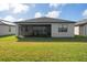 Back of the house featuring a screened in patio with lake views and a well-manicured lawn at 1889 Saddlewood Cir, Port Charlotte, FL 33953
