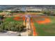 Aerial view of baseball fields and batting cages in community, with ponds and houses in distance at 1889 Saddlewood Cir, Port Charlotte, FL 33953