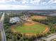Aerial view of baseball fields near a lake, showcasing community amenities with greenery and trees at 1889 Saddlewood Cir, Port Charlotte, FL 33953