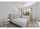 Bright bedroom featuring a decorative chandelier, a patterned bedspread, and a large window at 1889 Saddlewood Cir, Port Charlotte, FL 33953