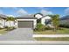 Charming single-story home with a two-car garage, beautifully landscaped yard, and neutral color palette at 1889 Saddlewood Cir, Port Charlotte, FL 33953