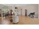 Bright living room with piano and hardwood floors near the entry and dining area at 2173 Muskogee Trl, Nokomis, FL 34275