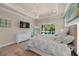 Comfortable bedroom featuring hardwood floors, tray ceiling, modern lighting and backyard views at 3407 155Th E Ave, Parrish, FL 34219