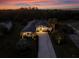 Twilight aerial view of the home with a long driveway and professional landscaping at 3407 155Th E Ave, Parrish, FL 34219