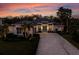 Beautiful house with a brick driveway, two-car garage, manicured lawn, and tropical sunset at 3407 155Th E Ave, Parrish, FL 34219