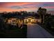 Twilight front view of the home with a long driveway and professional landscaping at 3407 155Th E Ave, Parrish, FL 34219