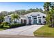 Bright exterior showcasing a pristine white facade, vibrant blue accents and a paver driveway at 3407 155Th E Ave, Parrish, FL 34219