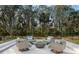 Outdoor patio with comfortable seating around a modern fire pit, overlooking a wooded backyard at 3407 155Th E Ave, Parrish, FL 34219