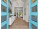 Elegant foyer featuring an open floor plan, light wood floors, modern decor, and a bright blue front door at 3407 155Th E Ave, Parrish, FL 34219