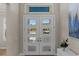 Bright foyer with a stylish white front door, light-colored walls, and a glimpse of the exterior through glass panels at 3407 155Th E Ave, Parrish, FL 34219