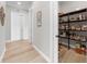 Hallway showcasing wood-look floors, access to a pantry, and stylish interior doors at 3407 155Th E Ave, Parrish, FL 34219