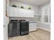 Bright laundry room boasts sleek appliances, white cabinetry, and stylish decor at 3407 155Th E Ave, Parrish, FL 34219