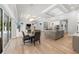 Open-concept living and kitchen area featuring tray ceilings, modern chandeliers, and wood plank flooring at 3407 155Th E Ave, Parrish, FL 34219