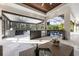 Elegant outdoor kitchen with stainless steel appliances, bar seating, and a view of the pool area at 3407 155Th E Ave, Parrish, FL 34219
