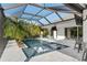Beautiful pool area with sun loungers, tropical plants, outdoor dining, and screened enclosure at 3407 155Th E Ave, Parrish, FL 34219