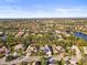 Expansive aerial view of a residential neighborhood, lush landscaping, and a tranquil lake at 6815 Turnberry Isle Ct, Lakewood Ranch, FL 34202
