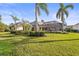 Spacious backyard with tropical landscaping, featuring palm trees and a screened-in lanai at 6815 Turnberry Isle Ct, Lakewood Ranch, FL 34202