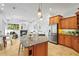 Open kitchen design with granite island, stainless steel refrigerator, and light wood cabinetry overlooking the living room at 6815 Turnberry Isle Ct, Lakewood Ranch, FL 34202
