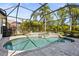 Screened-in pool features a waterfall, spa, and tropical landscaping at 6815 Turnberry Isle Ct, Lakewood Ranch, FL 34202
