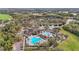Aerial view of a community center with pools, clubhouse, and sports facilities surrounded by trees at 6815 Turnberry Isle Ct, Lakewood Ranch, FL 34202