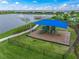 Aerial view of a fenced-in playground with slides and a shade cover near a pond at 8358 Redonda Loop, Lakewood Ranch, FL 34202