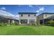 A view of backyard featuring well-maintained lawn and gray two-story house at 10109 Milky Way Cir, Sarasota, FL 34241