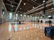 Indoor basketball court with polished wood flooring and multiple hoops in a well-lit gymnasium at 10109 Milky Way Cir, Sarasota, FL 34241