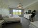 Bright bedroom boasts an accent wall, gray wood-look flooring, and a large window with peaceful outdoor views at 10109 Milky Way Cir, Sarasota, FL 34241