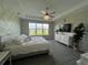 Bright bedroom features an accent wall, gray wood-look flooring, and a large window with serene views at 10109 Milky Way Cir, Sarasota, FL 34241