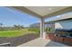 Covered outdoor kitchen area with stainless steel BBQ grill and bar area overlooking the community pond at 10109 Milky Way Cir, Sarasota, FL 34241